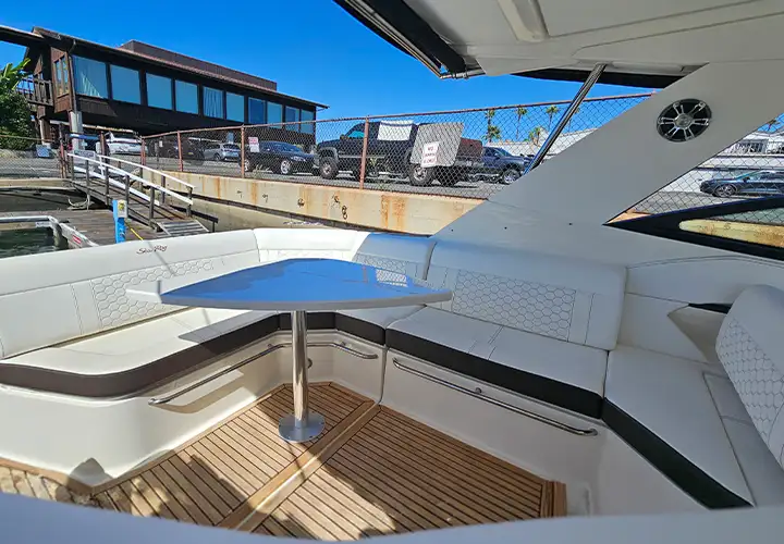 Shaded wraparound cockpit lounge with a table and teak-look flooring