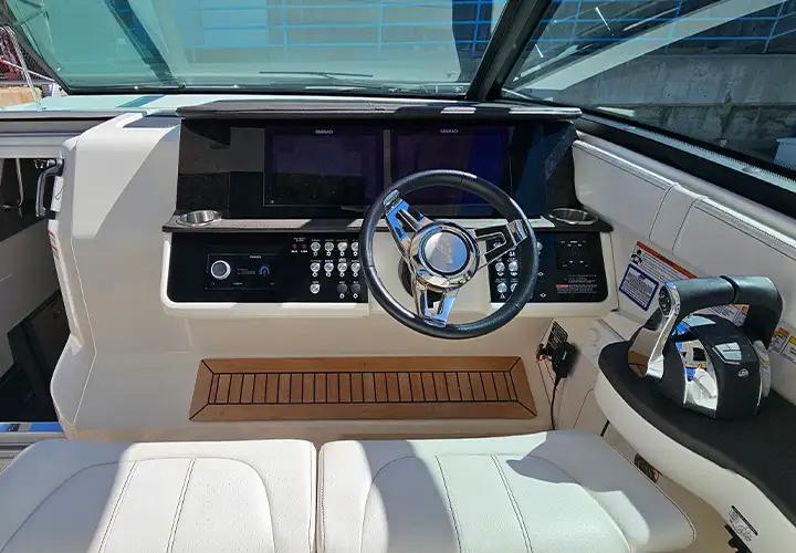Twin navigation displays and steering controls behind the Sea Ray windshield