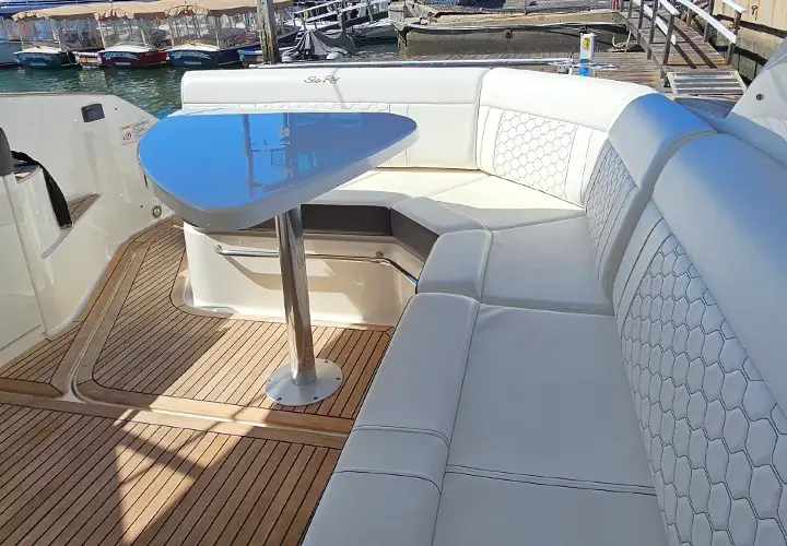 Close view of the cockpit table, cushioned lounge and teak-look flooring
