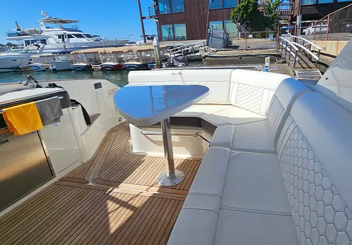 Wraparound white cockpit seating and a table overlooking Newport Harbor